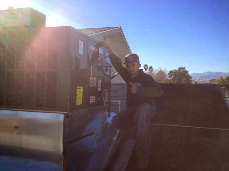 HVAC technician performing HVAC Inspection on a rooftop unit in Northport